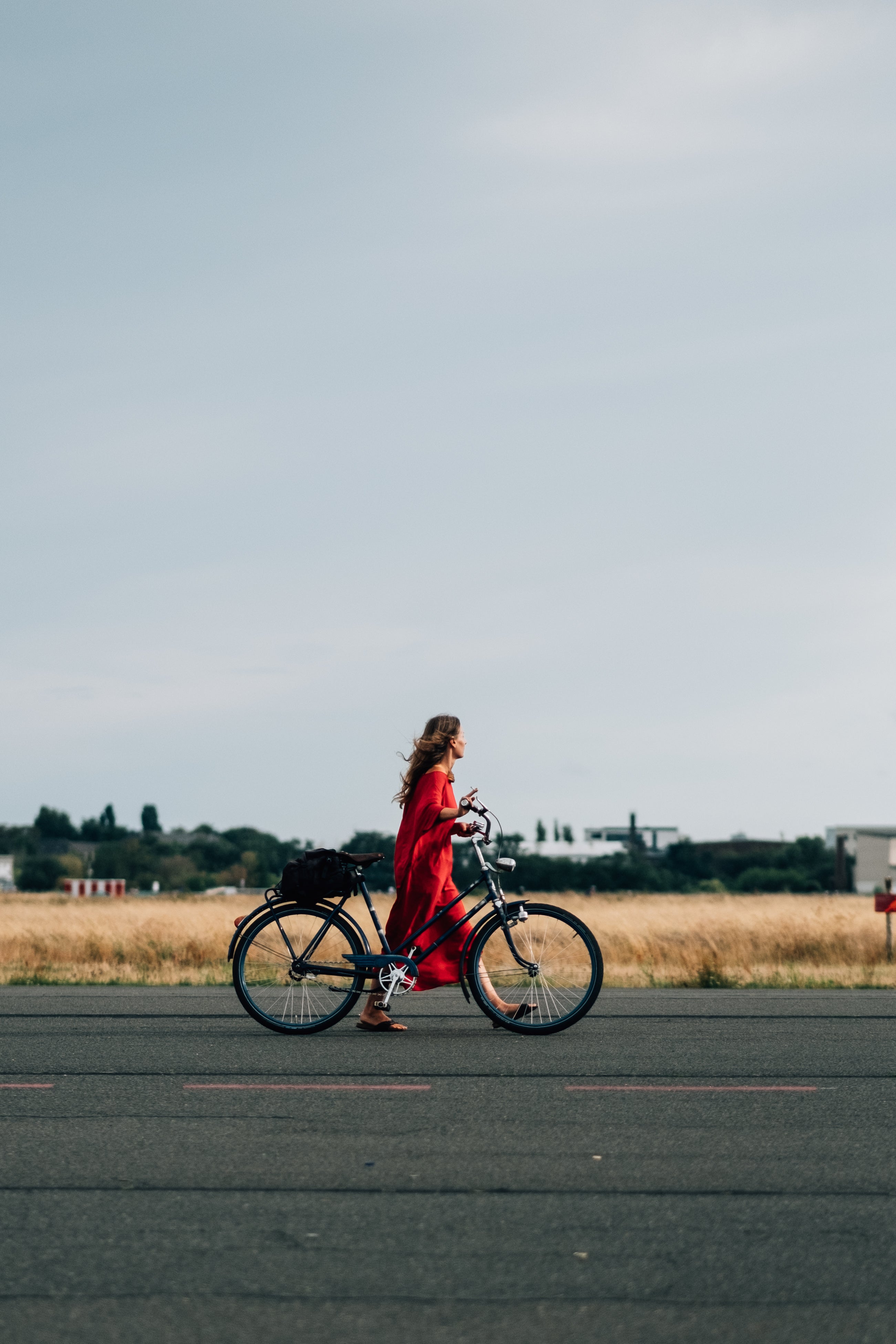 files/person-in-red-dress-walks-bicycle-down-the-road.jpg